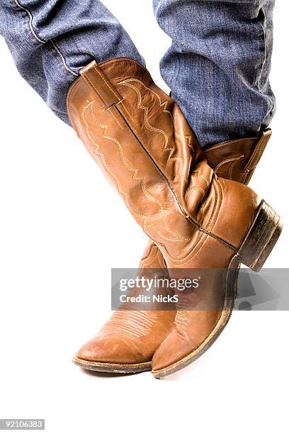 close-up of feet in cowboy boots and jeans - cowboy boots stock pictures, royalty-free photos & images