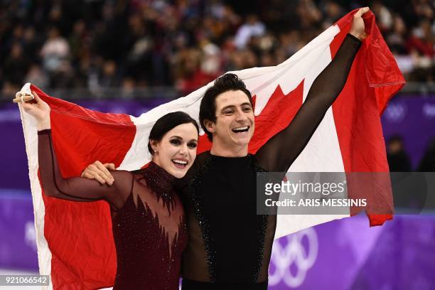 Canada's Tessa Virtue and Canada's Scott Moir celebrate following the venue ceremony after the ice dance free dance of the figure skating event...