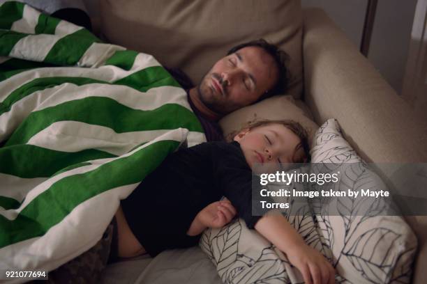 Toddler and dad take a nap in the sofa