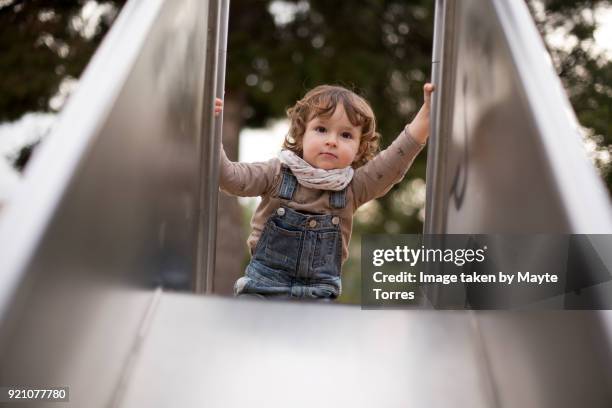 toddler at the playground climbing at the slide - playground equipment stock pictures, royalty-free photos & images