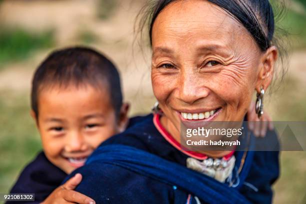laosiana madre llevando a su pequeño hijo, pueblo en el norte de laos - cultura laosiana fotografías e imágenes de stock