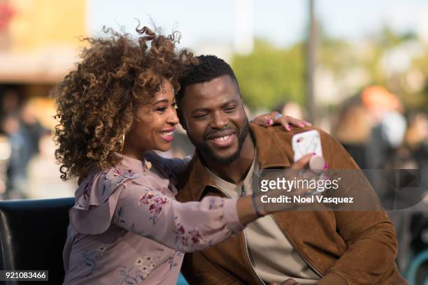 Winston Duke takes a selfie with Tanika Ray at "Extra" at Universal Studios Hollywood on February 19, 2018 in Universal City, California.