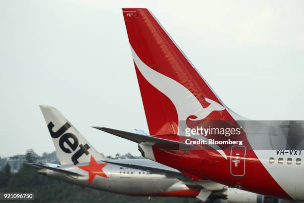 Aircraft operated by Qantas Airways Ltd., right, and its low-cost unit Jetstar Airways stand on the tarmac at Sydney Airport in Sydney, Australia, on...
