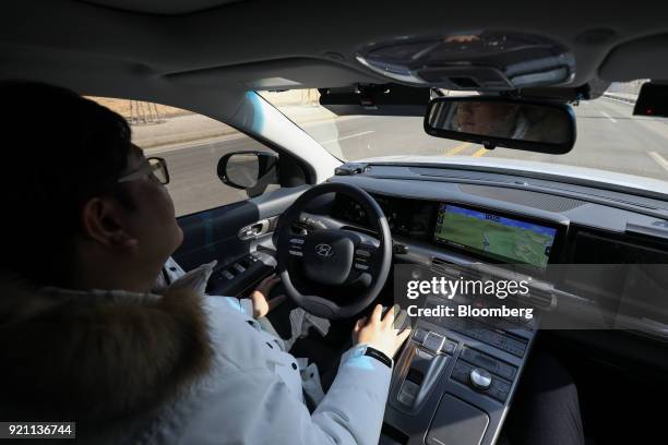 An engineer rides in the driver's seat of a Hyundai Motor Co. Nexo autonomous fuel cell electric vehicle during a test drive in Pyeongchang, Gangwon...