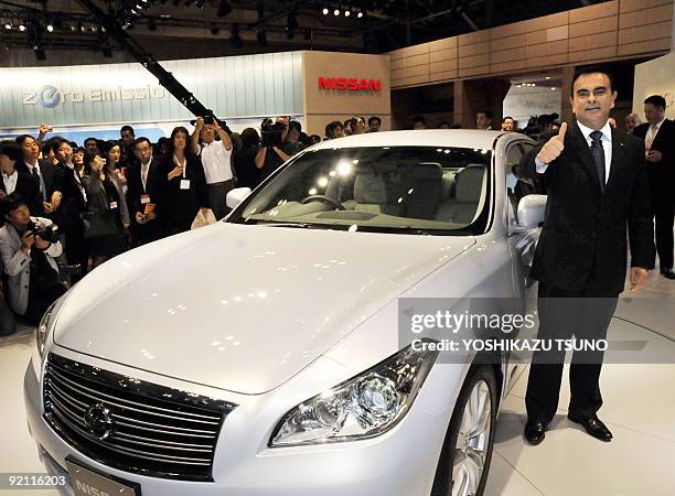 Japan's auto giant Nissan Motor president and CEO Carlos Ghosn displays the new luxury sedan "Fuga" at the press preview of the Tokyo Motor Show in...