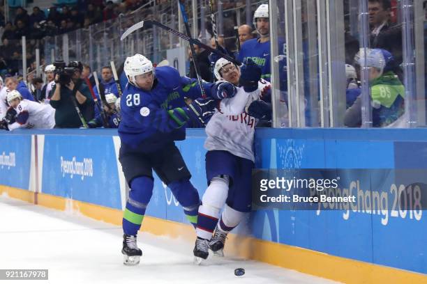 Ales Kranjc of Slovenia checks Kristian Forsberg of Norway in the first period during the Men's Play-offs Qualifications game on day eleven of the...