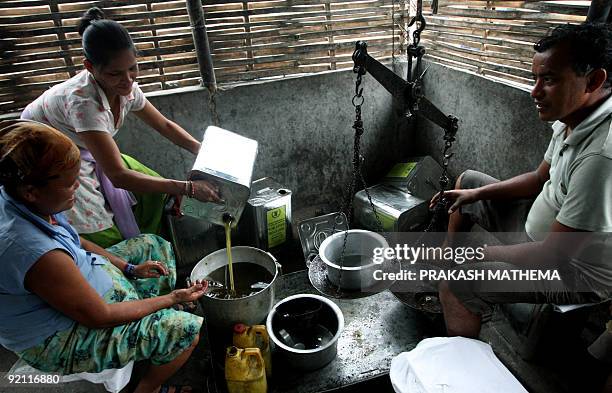 Nepal-Bhutan-refugees-family,FEATURE by Claire Cozens Bhutanese refugees collect oil from a distribution facility at The Beldangi II Refugee Camp...