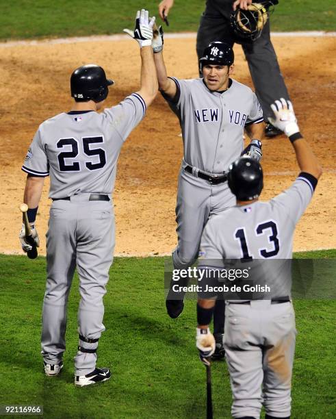 Johnny Damon of the New York Yankees celebrates with teammates Mark Teixeira and Alex Rodriguez after Damon hit a two run home run during the eighth...