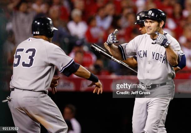Johnny Damon of the New York Yankees celebrates with teammate Melky Cabrera after Damon hit a two run home run during the eighth inning in Game Four...