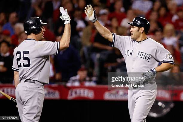 Johnny Damon of the New York Yankees celebrates with teammate Mark Teixeira after Damon hit a two run home run during the eighth inning in Game Four...