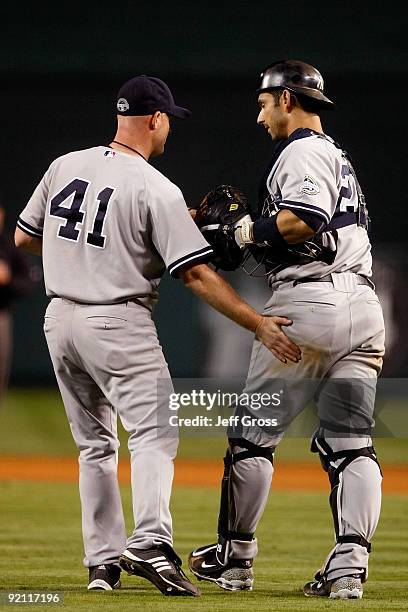 Chad Gaudin of the New York Yankees celebrates with teammate Jorge Posada after defeating the Los Angeles Angels of Anaheim 10-1 in Game Four of the...