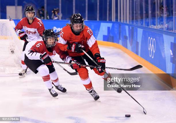 Dominique Ruegg of Switzerland controls the puck against Sena Suzuki of Japan in the third period during the Women's Ice Hockey Classification game...