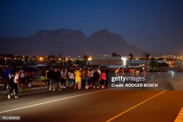 Group pf people, including Cyril Ramaphosa , the newly sworn-in South African president, walk on an early morning from Guguletu township, to Athlone...
