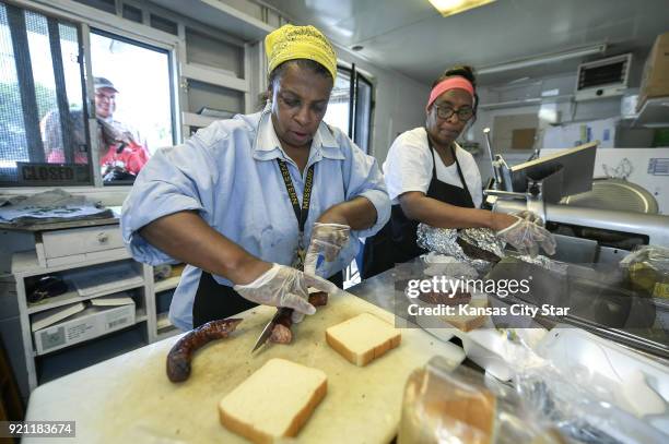 Deborah Jones, left, slices sausage for a lunch order while her sister, Mary Jones Mosley, assists in the tiny kitchen area of Jones BBQ in Kansas...