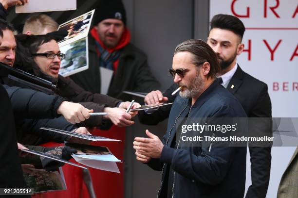 Joaquin Phoenix smokes a cigarette and signs autographs for fans before attending the 'Don't Worry, He Won't Get Far on Foot' photo call during the...