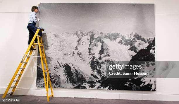Rudolf Stingel's monumental painting of the Tyrolean Alps in Italy, based on a historic photograph, is prepared for exhibition at Sotheby's in...