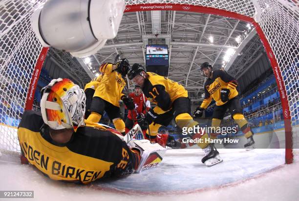 Danny Aus Den Birken of Germany makes a save against Raphael Diaz and Denis Hollenstein of Switzerland in the first period during the Men's Ice...