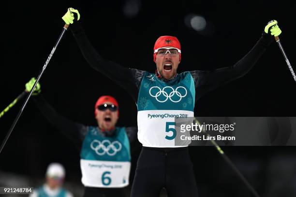 Johannes Rydzek of Germany celebrates winning the gold medal followed by silver medallist Fabian Riessle of Germany during the Nordic Combined...