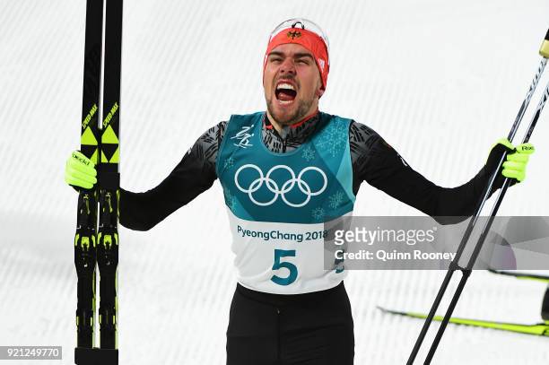Johannes Rydzek of Germany celebrates winning the gold medal during the Nordic Combined Individual Gundersen 10km Cross-Country on day eleven of the...