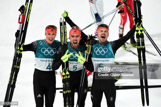 Johannes Rydzek of Germany celebrates winning the gold medal with silver medallist Fabian Riessle of Germany and bronze medallist Eric Frenzel of...