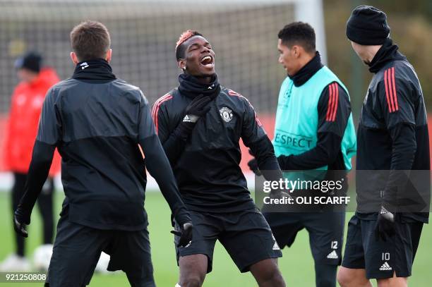 Manchester United's French midfielder Paul Pogba laughs during a team training session at the club's training complex near Carrington, west of...