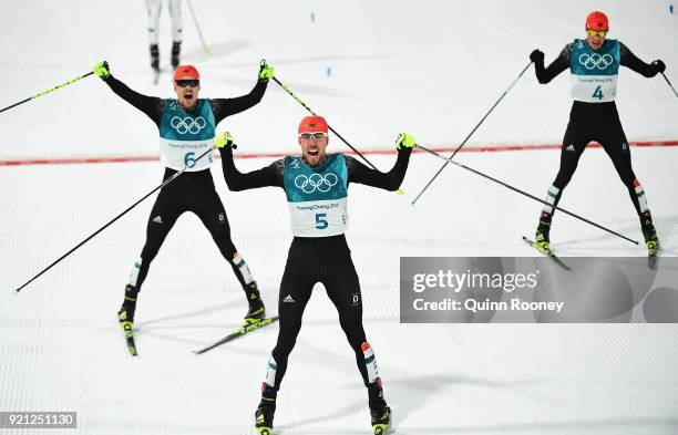 Johannes Rydzek of Germany celebrates winning the gold medal with silver medallist Fabian Riessle of Germany and bronze medallist Eric Frenzel of...