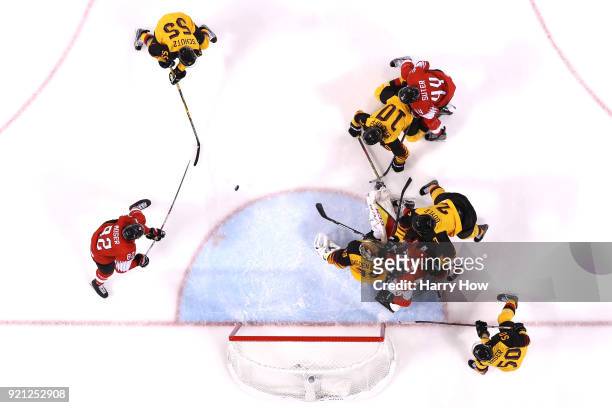 Simon Moser of Switzerland shoots and scores against Danny Aus Den Birken of Germany in the second period during the Men's Ice Hockey Qualification...