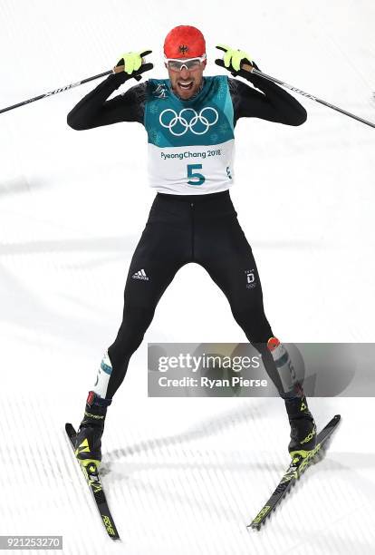 Johannes Rydzek of Germany celebrates after he crossed the line to win Gold in the Nordic Combined Individual Gundersen 10km Cross-Country on day...