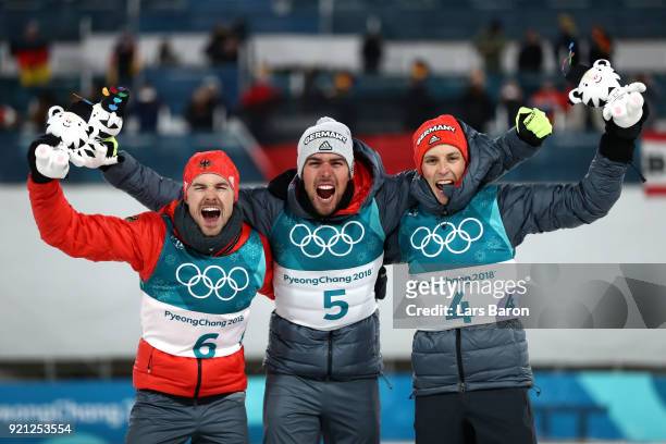 Johannes Rydzek of Germany celebrates winning the gold medal with silver medallist Fabian Riessle of Germany and bronze medallist Eric Frenzel of...