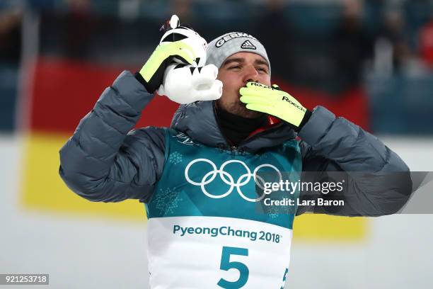 Johannes Rydzek of Germany celebrates winning the gold medal during the victory ceremony for the Nordic Combined Individual Gundersen 10km...