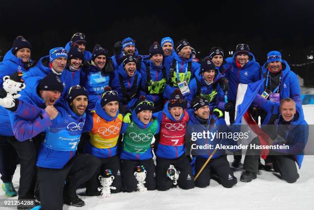 Gold medalists Marie Dorin Habert, Anais Bescond, Simon Desthieux and Martin Fourcade of France celebrate with their team after the victory ceremony...