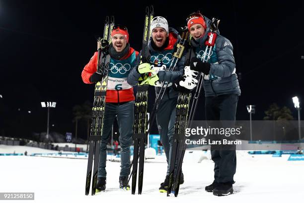 Johannes Rydzek of Germany celebrates winning the gold medal with silver medallist Fabian Riessle of Germany and bronze medallist Eric Frenzel of...