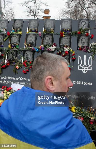 Man lays flowers to the Memorial with a portraits of mass shootings victims. Ukraine pays tribute to the victims of the 2013-2014 anti-government...