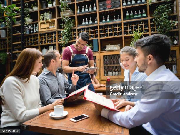 ober aannemen van order aan een groep in een restaurant met behulp van een tablet - demanding stockfoto's en -beelden