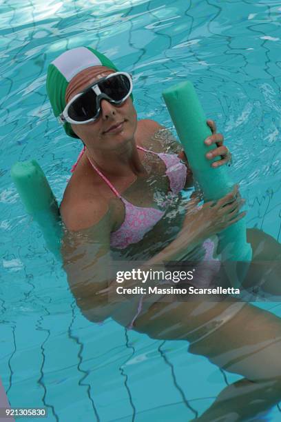 european woman relaxing in pool sitting on pool noodle - piscina ストックフォトと画像