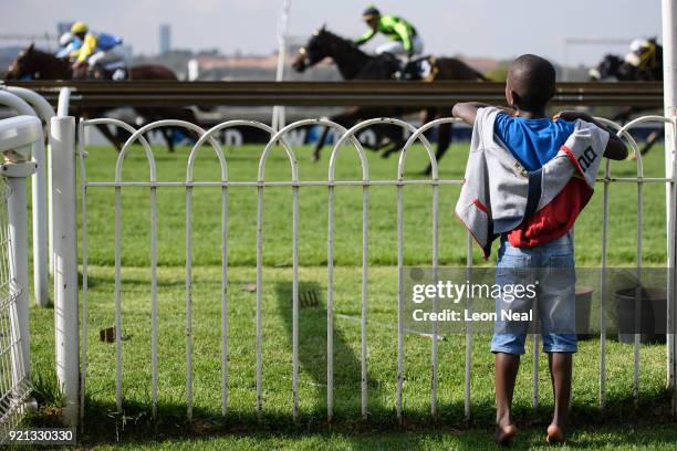 Young child watches the final seconds of a horse race at the Turffontein race course on March 25, 2017 in Johannesburg, South Africa. Those born...