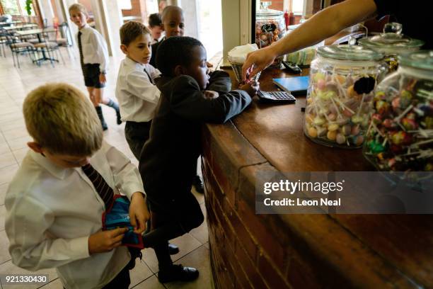 Students from the King Edward VII school queue for sweets and snacks at the tuck shop on March 29, 2017 in Johannesburg, South Africa. Those born...