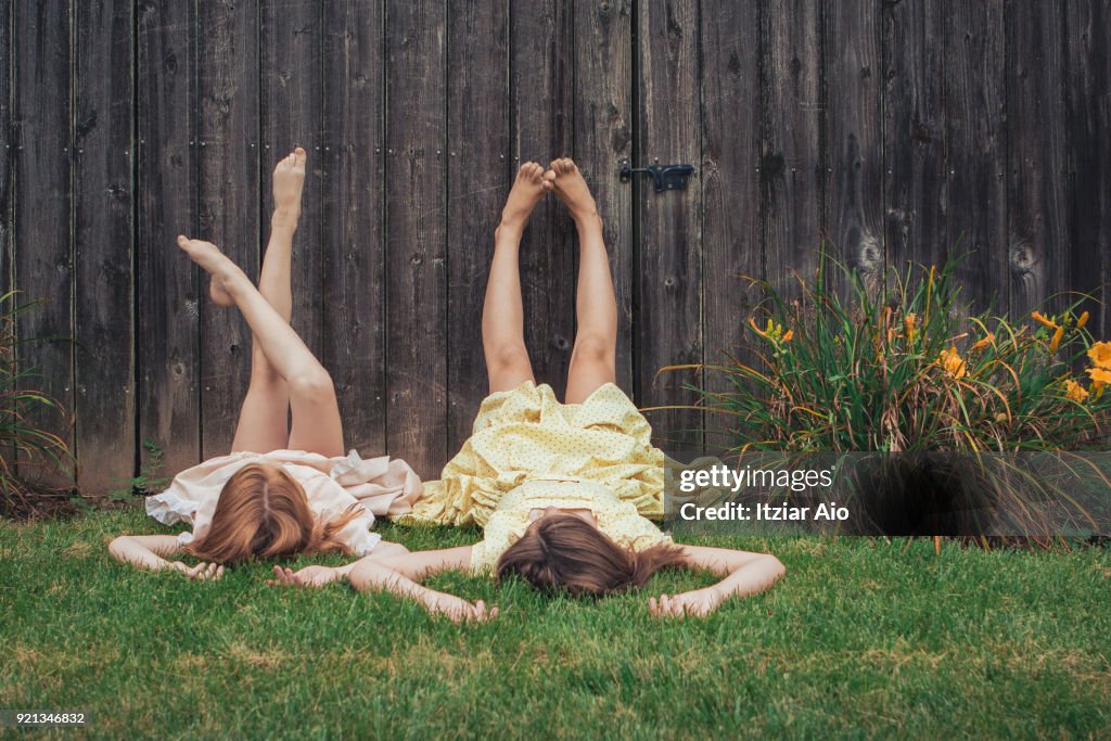 Two sisters lying on the grass