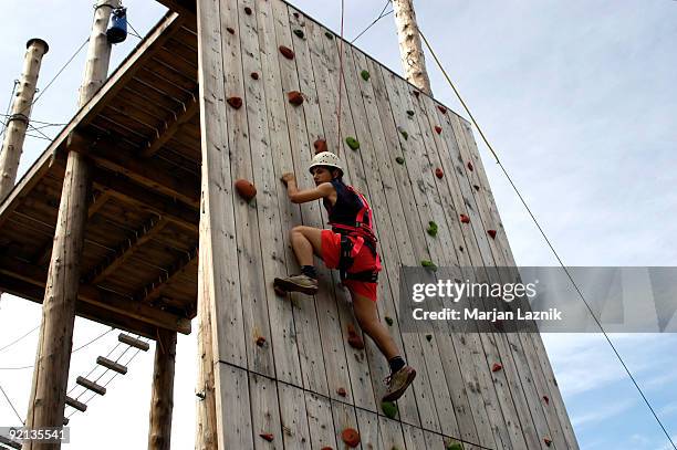 climber on the wood climbing wall in amusement park - climbing wall stock pictures, royalty-free photos & images