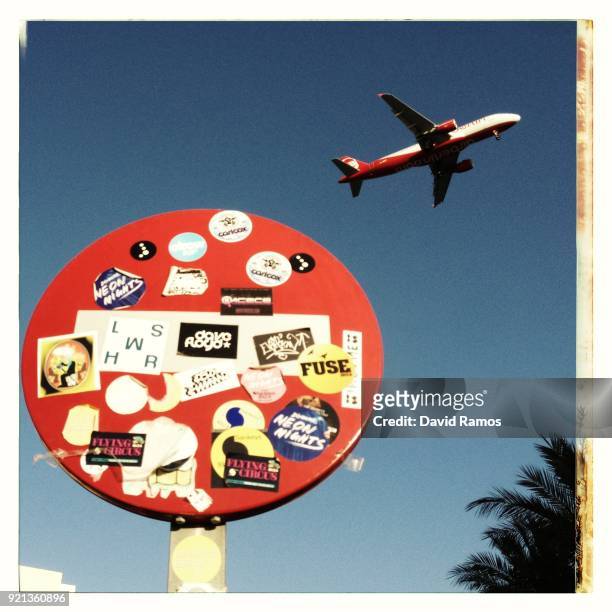 Plane is flying over the Playa d'En Bossa on August 22, 2013 in Ibiza, Spain. The small island of Ibiza lies within the Balearics islands, off the...
