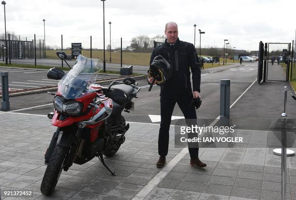 Britain's Prince William, Duke of Cambridge, rides a motorcycle during a visit to Triumph Motorcycles in Hinckley in central England on February 20,...