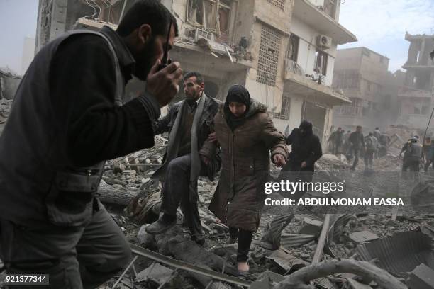 Graphic content / A member of the Syrian civil defence speaks on a wireless transmitter as other civilians flee from an area hit by a reported regime...