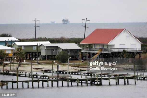 Offshore oil platforms stand past homes in the Gulf of Mexico near Grand Isle, Louisiana, U.S., on Thursday, Feb. 8, 2018. U.S. Oil explorers added...