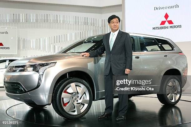 Mitsubishi Motors Corp. President Osamu Masuko poses with the company's concept plug-in hybrid electric vehicle 'PX-MiEV' during the 41st Tokyo Motor...