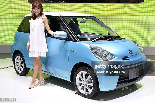 Model poses with the new Daihatsu Motor Co.'s concept vehicle 'e:S' during the 41st Tokyo Motor Show at Makuhari Messe on October 21, 2009 in Chiba,...