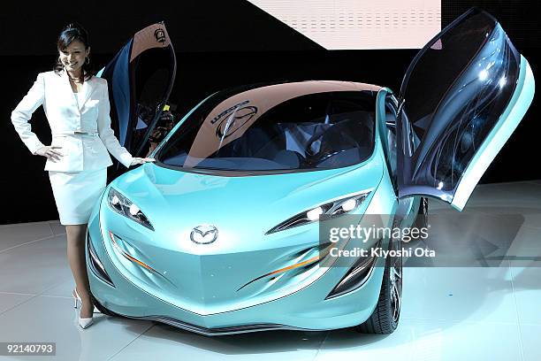 Model poses with the new Mazda Motor Corp.'s compact concept vehicle 'Kiyora' during the 41st Tokyo Motor Show at Makuhari Messe on October 21, 2009...