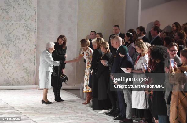 Queen Elizabeth II greets Chief Executive of the British Fashion Council Caroline Rush and Anna Wintour as she attends the Richard Quinn show during...