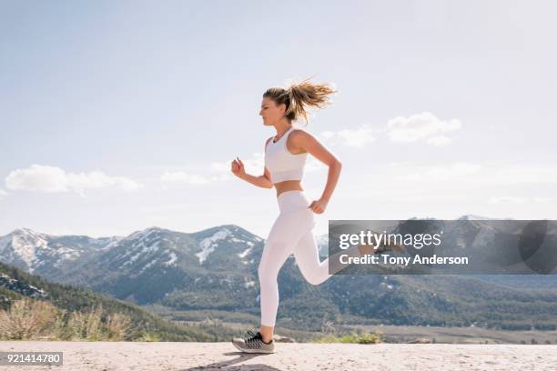 young woman running in mountain setting - leggings stock pictures, royalty-free photos & images