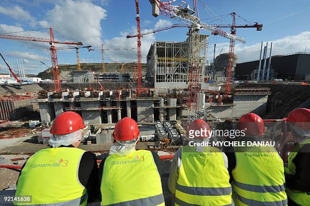 People stand in front of the French state electicity utility EDF construction site of the third-generation European Pressurised Water Reactor in...