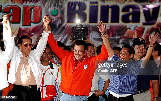 Philippine former President Joseph Estrada raises his arms with running mate Makati City Mayor Jejomar Binay and Senate President Juan Ponce Enrile...